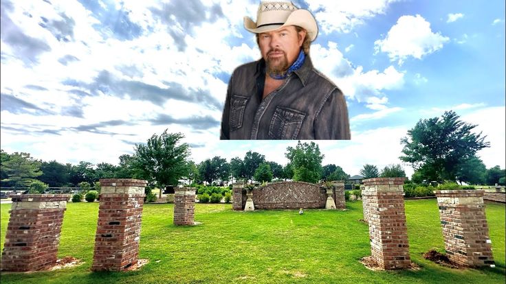 This may contain: a man wearing a cowboy hat standing in front of a cemetery